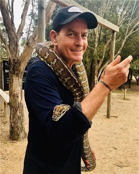 Charlie Sheen modela con una serpiente alrededor del cuello